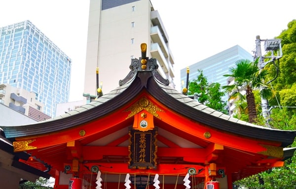 背景にビルがある社殿の風景